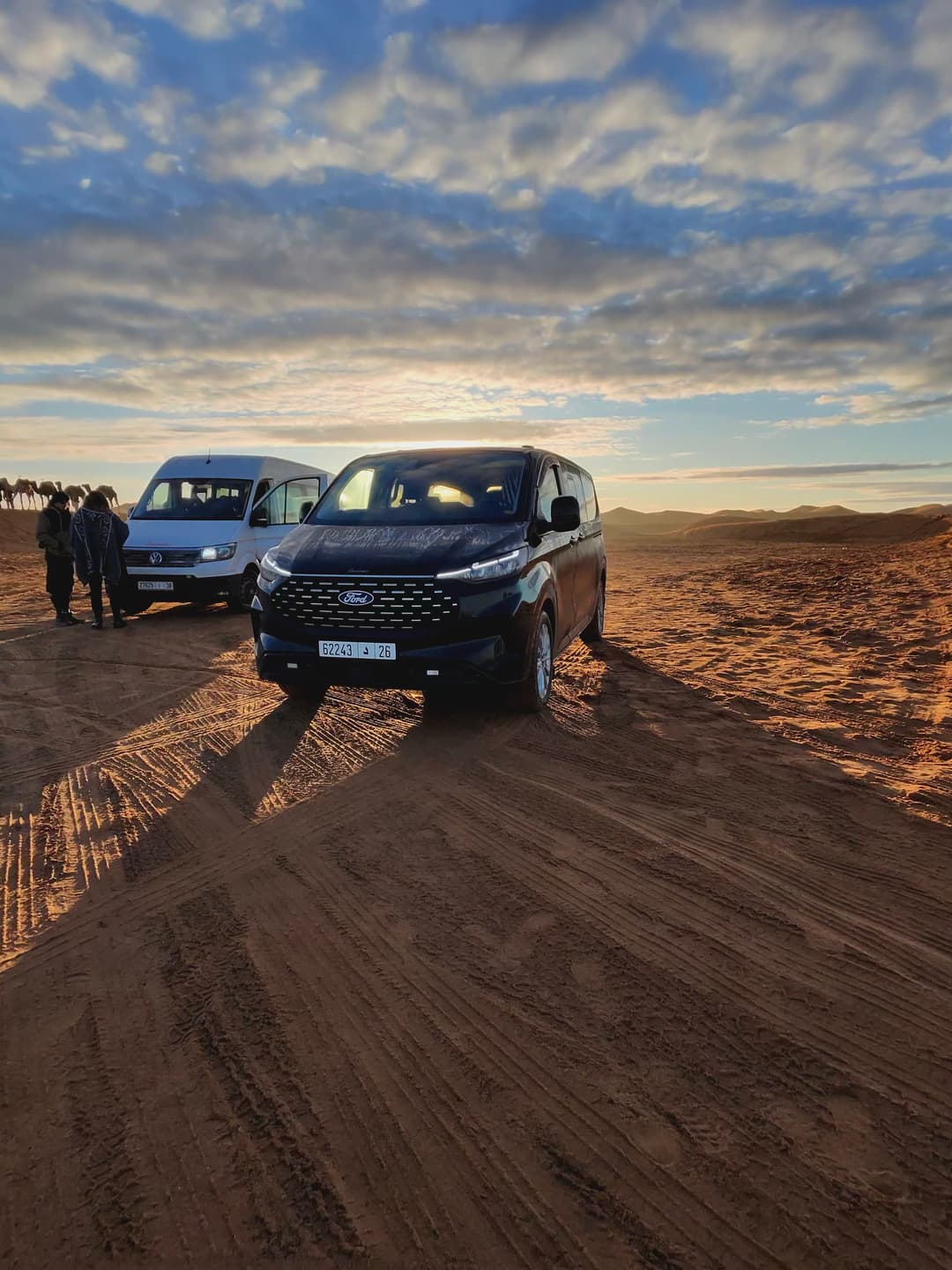 Arhhal vehicles beside the dunes at sunset
